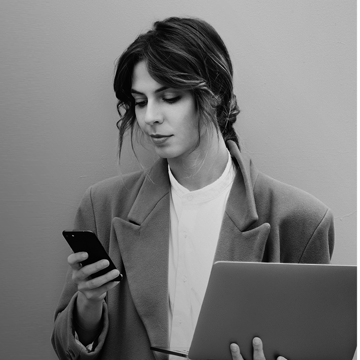 młoda kobieta spoglądająca na trzymany w dłoni telefon