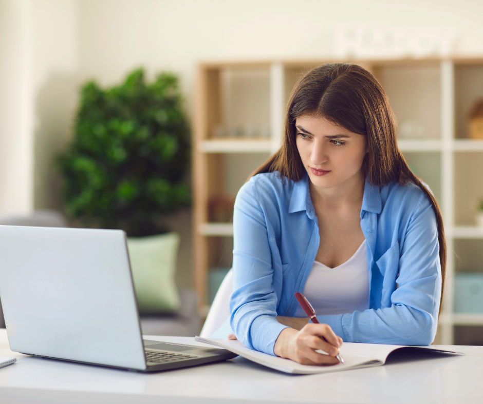 Młoda kobieta robi notatki. Zdjęcie poglądowe.