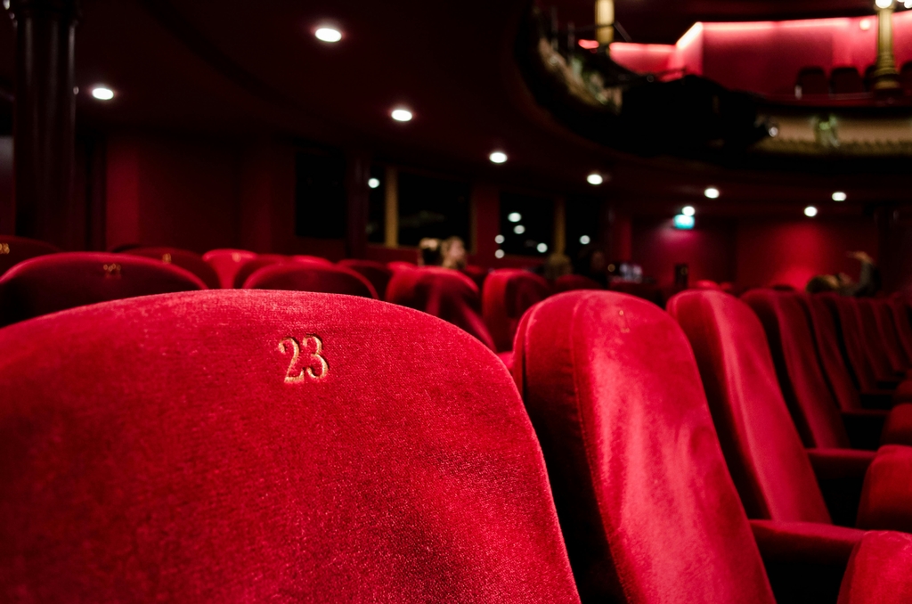 A decorative element: Chairs upholstered in red fabric in the theater hall, with the number 23 visible on one of them.