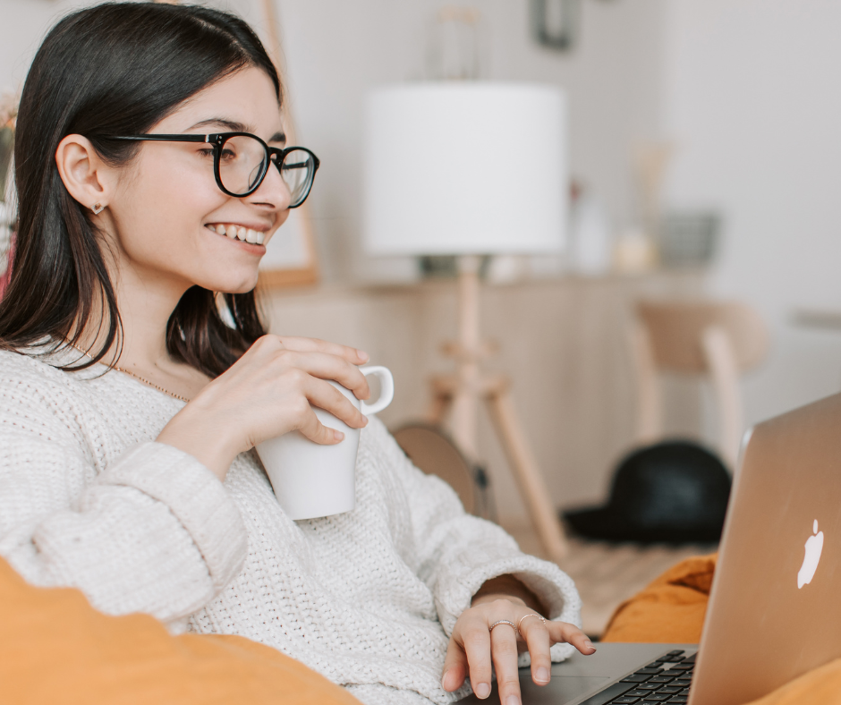 Uśmiechnięta dziewczyna patrzy w ekran komputera. Zdjęcie poglądowe.