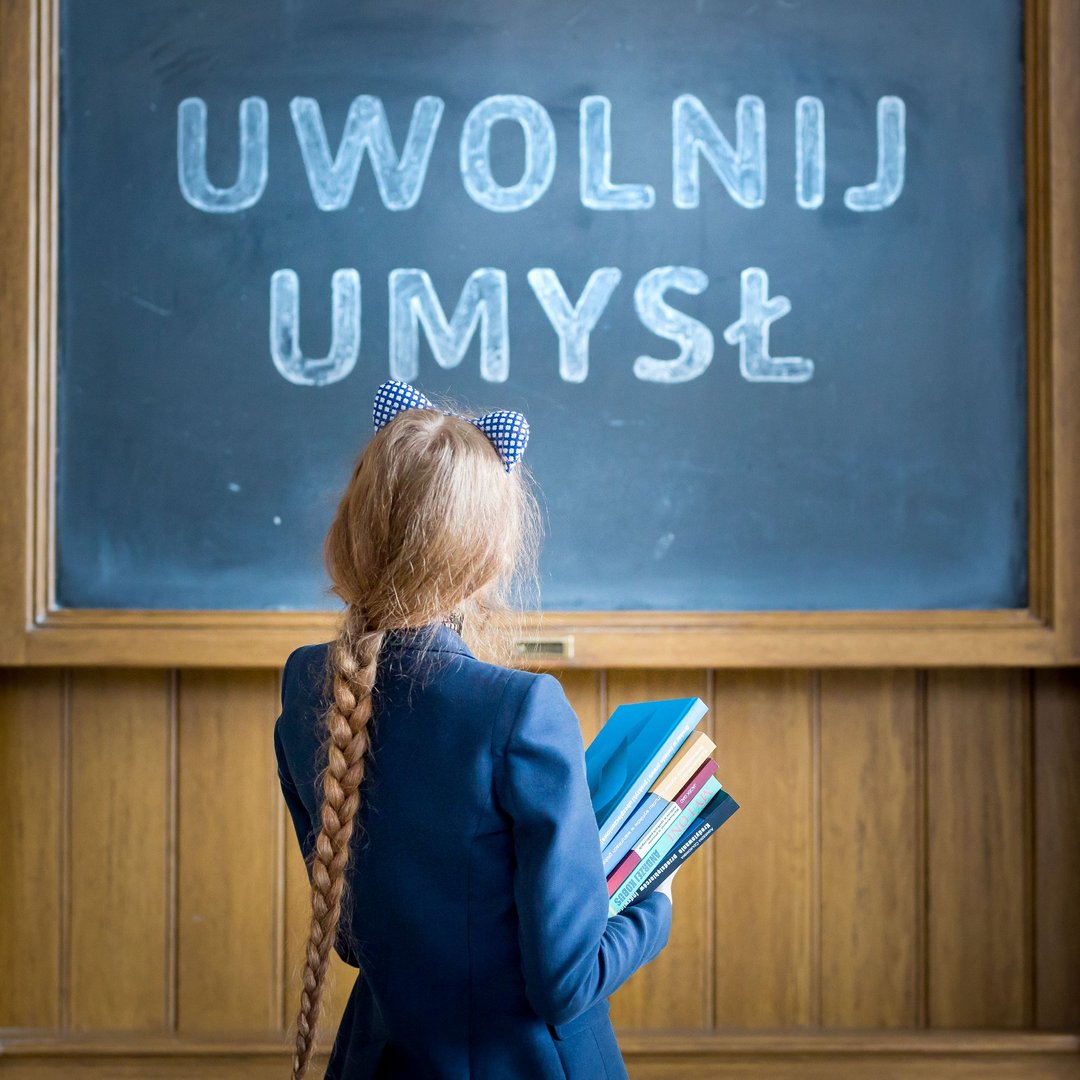 A University of Lodz student in front of a chalkboard.