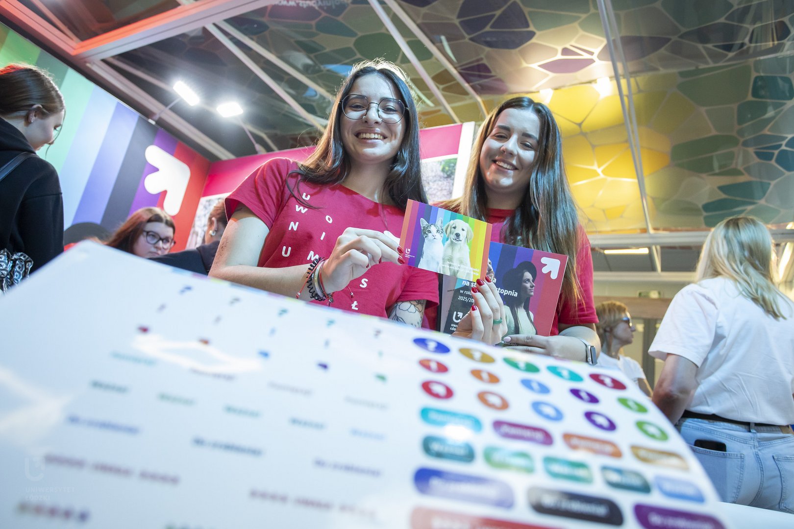 [Translate to English:] Two University of Lodz students holding up University of Lodz flyers.