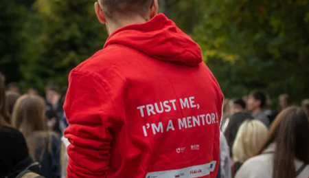 Zdjęcie studenta z czerwonej bluzie z napisem Trust me I'm a Mentor