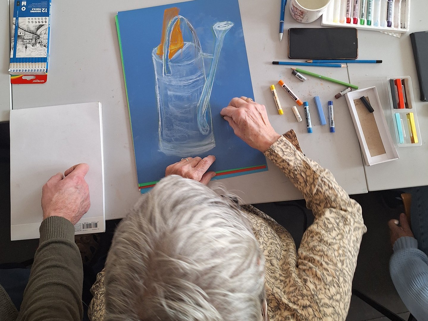 Seniorzy malują w pracowni plastycznej