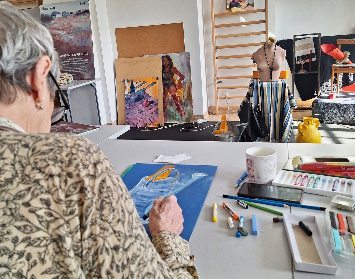 Seniorzy malują w pracowni plastycznej