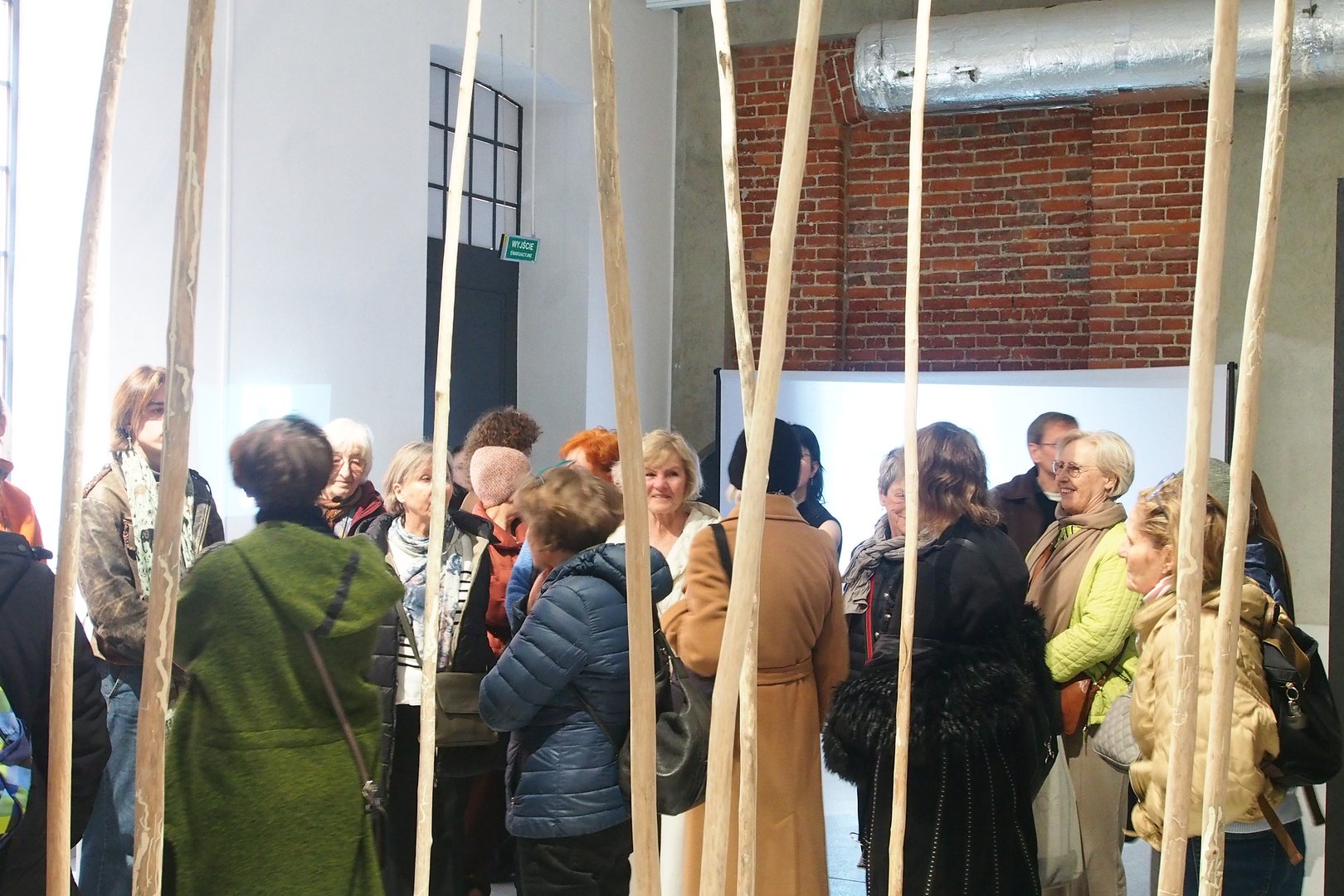 Seniorzy zwiedzają wystawę w Fabryce Sztuki