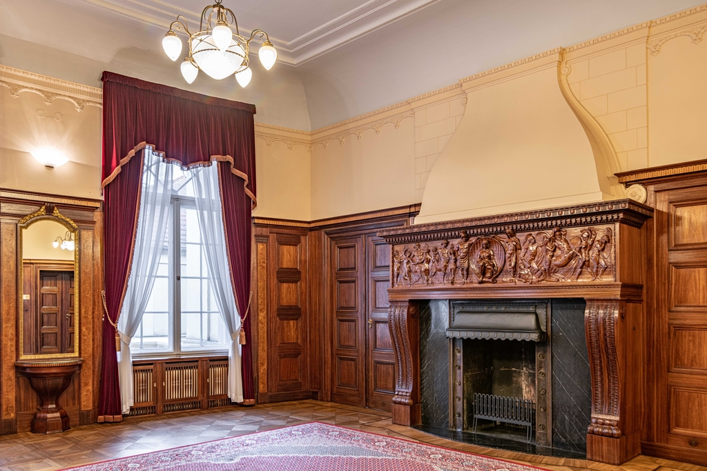 Fragment salonu wraz z znajdującym się w nim zabytkowym kominkiem