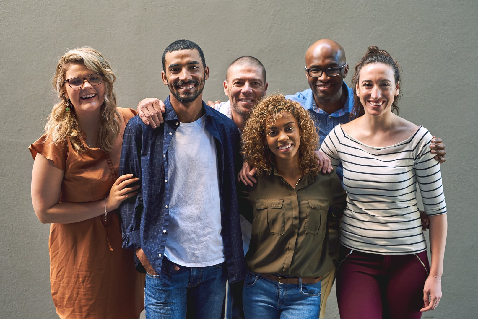 Friends all grouped together. Shot of a group cheerful friends standing together for a portrait while looking at the camera. Element dekoracyjny