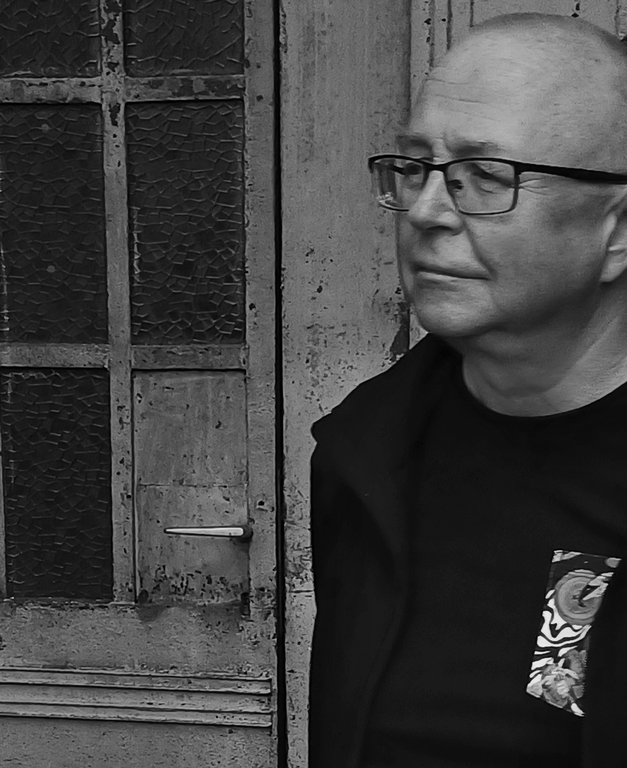 Jerzy Grzegorski, fot. Marcin Polak Czarno-białe zdjęcie portret mężczyzny. Starszy mężczyzna ubrany na czarno, na nosie ma okulary. Jest łysy.