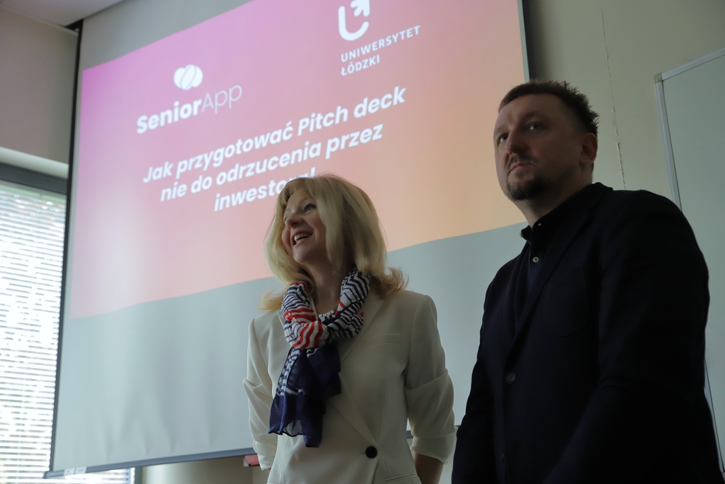 Prowadzący spotkanie na tle prezentacji