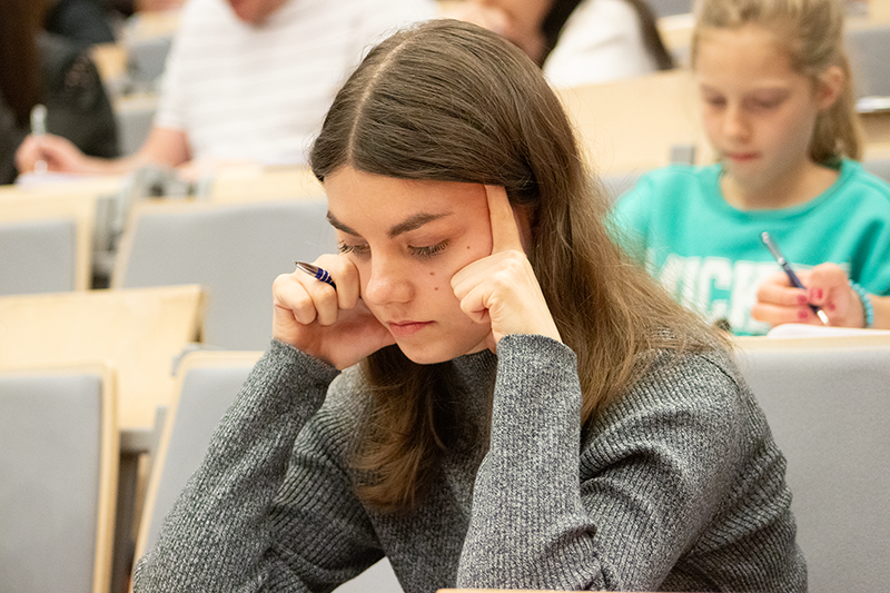 Uczestniczka dyktanda rozmyślająca nad poprawnym zapisem słowa