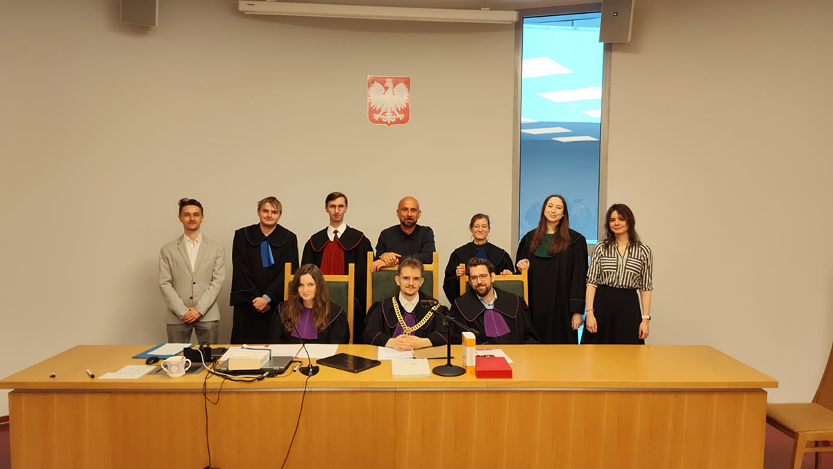Grupa studentów i wykładowca w sali sądowej