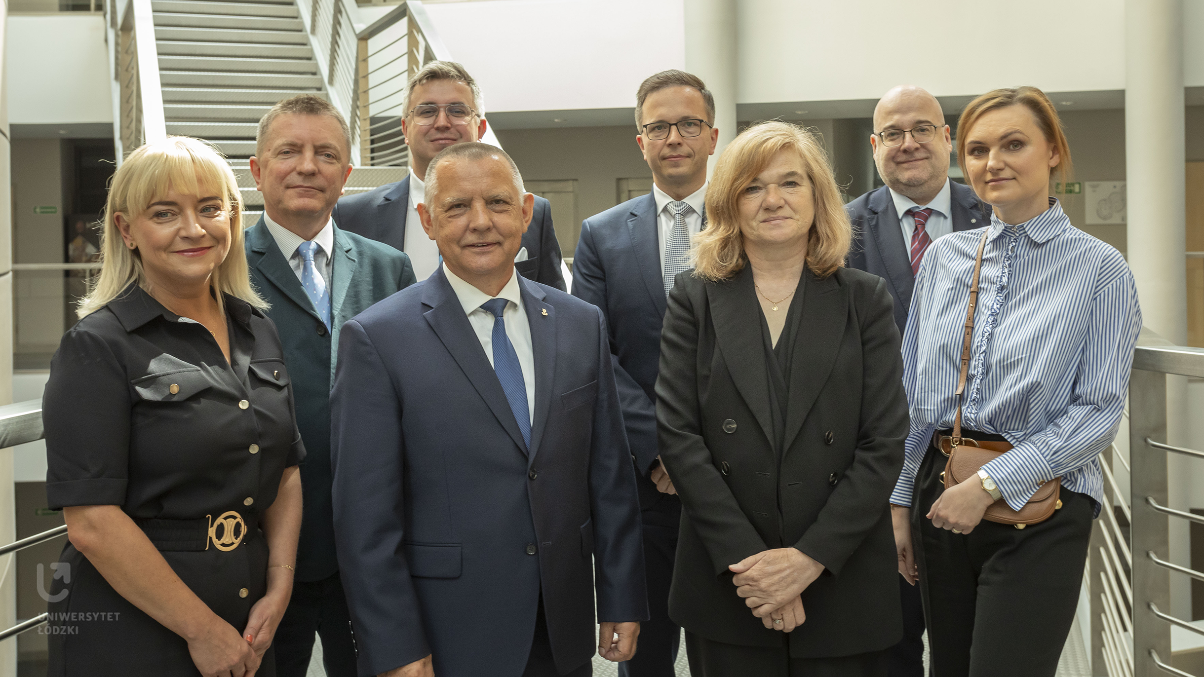 Trzy elegancko ubrane kobiety i czterech mężczyzn w garniturach