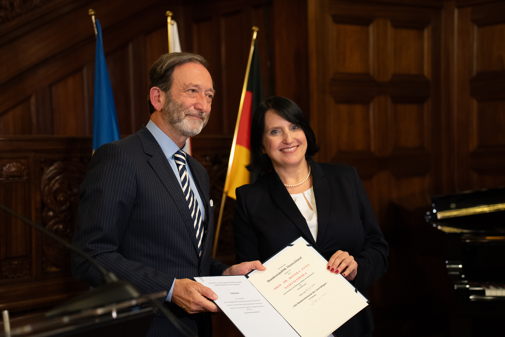 Ambasador Niemiec - mężczyzna w garniturze o szpakowatej brodzie oraz honorowa konsul Niemiec - brunetka w czarnym żakiecie