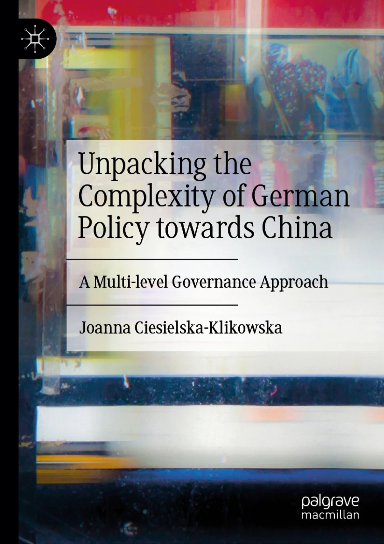 Okładka książki „Unpacking the Complexity of German Policy towards China: A Multi-level Governance Approach” autorstwa Joanny Ciesielskiej-Klikowskiej, wydanej przez Palgrave Macmillan. Tło przedstawia abstrakcyjną, kolorową kompozycję z refleksami i rozmytymi sylwetkami, symbolizującą złożoność polityki międzynarodowej i wielopoziomowego zarządzania.