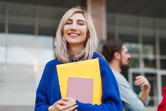 uśmiechnięta kobieta przed budynkiem