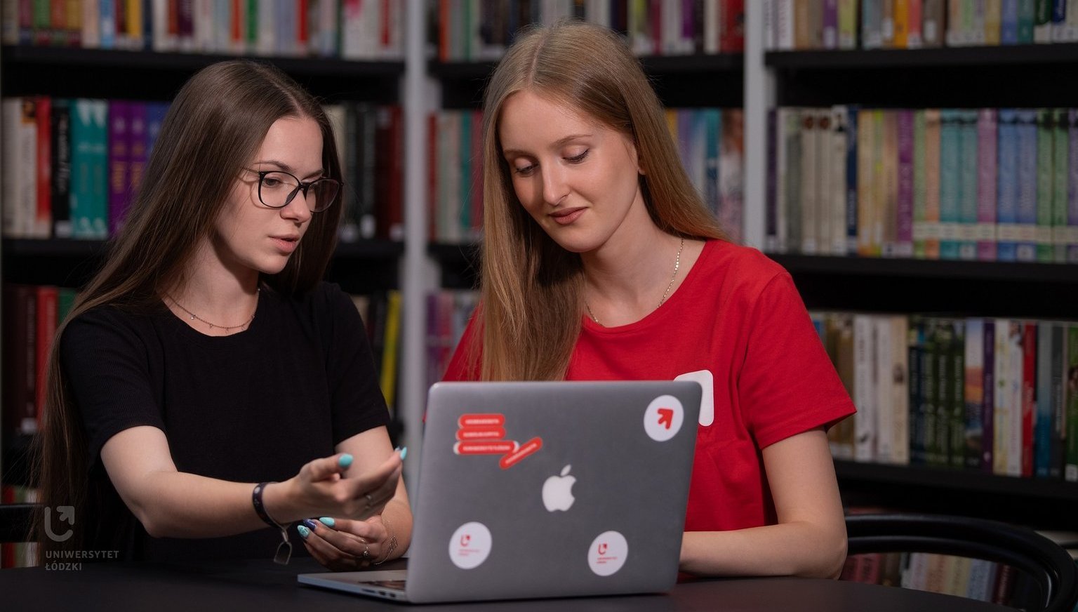Dwie studentki siedzą przy laptopie.