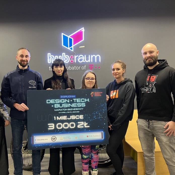 The winning team holding a check for PLN 3,000. The team consists of four women, two men, who are looking at the camera and smiling