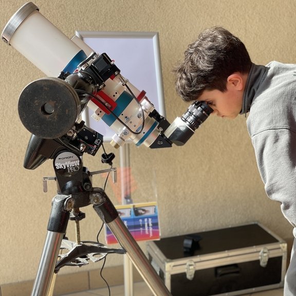 dziecko oglądające zaćmienie przez teleskop