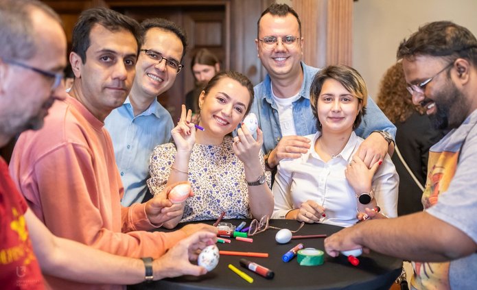 Osoby z różnych krajów ozdabiające pisanki przy jednym stoliku