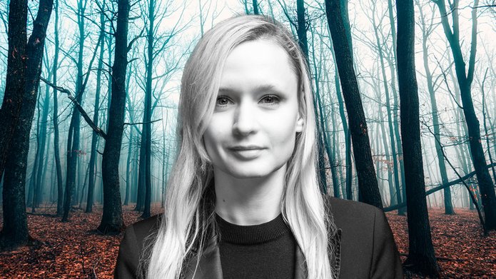 Dr Marta Jablonska against a background of a forest illuminated by bright blue light