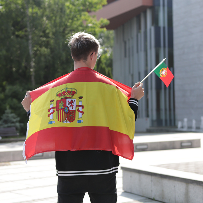 Chłopak z flagą Portugalii na tle budynku wydziału