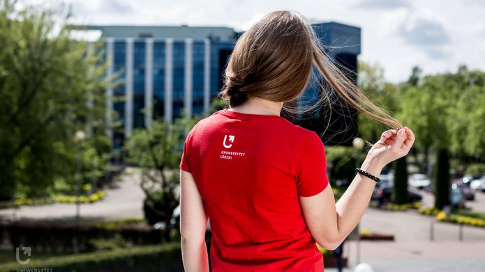Dziewczyna odwrócona tyłem, wpatrzona w budynek Biblioteki UŁ