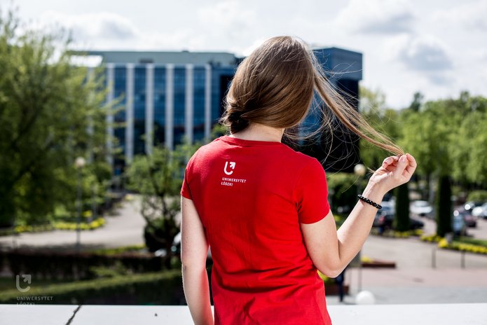 Dziewczyna odwrócona tyłem, wpatrzona w budynek Biblioteki UŁ