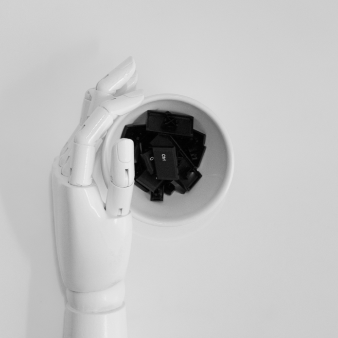 Sztuczna biała dłoń sięga po czarne klawisze. Zdjęcie poglądowe.