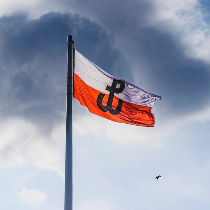 Polska flaga z symbolem Powstania Warszawskiego