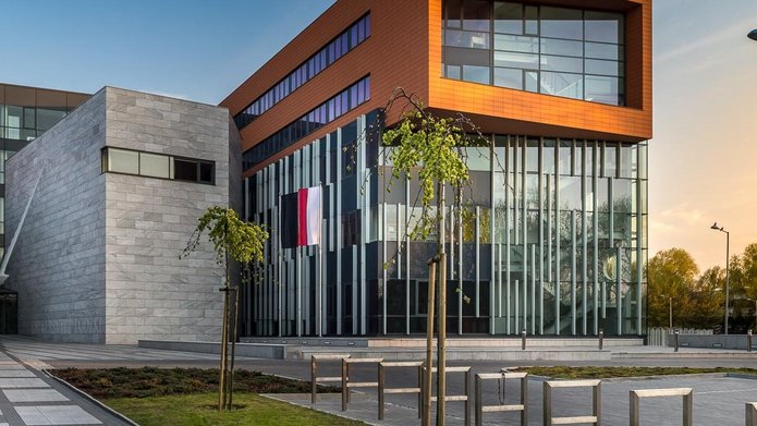 Budynek Wydziału Filologicznego Uniwersytetu Łódzkiego. Nowoczesny budynek z szarych dużych bloków marmurowych i dużo przeszklonych powierzchni.