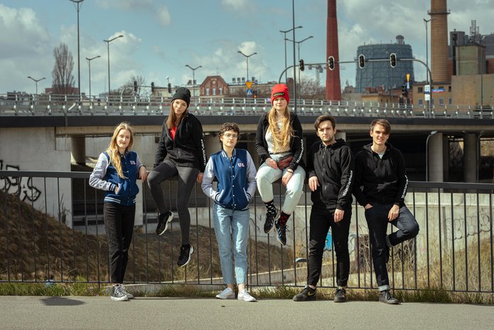 4 studentki i 2 studentów UŁ na tle ulicy i zabudowań miejskich