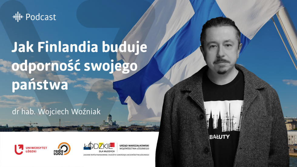 Zdjęcie portretowe dra hab. Wojciecha Woźniaka na tle powiewającej fińskiej flagi