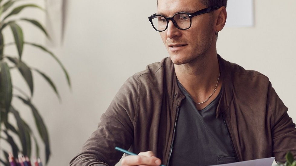 a decorative element: a young man wearing glasses sitting at a desk and working