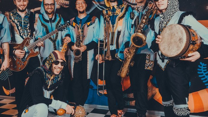 zespół muzyków w kolorowych strojach z afrykańskimi instrumentami