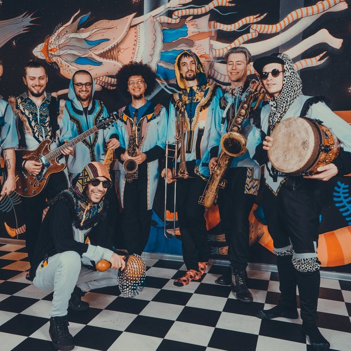 a group of musicians wearing colorful costumes and holding African instruments