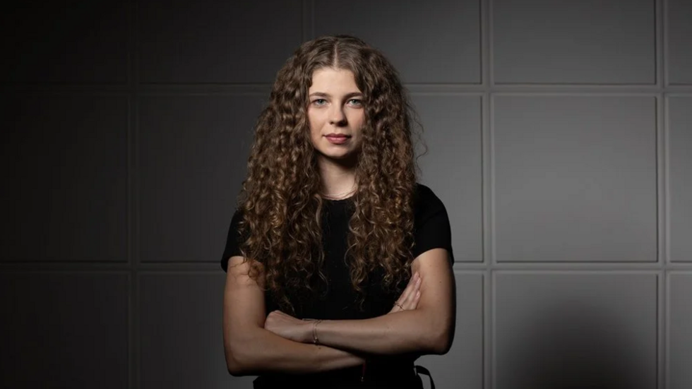 Student of UniLodz stands in a confident manner with her arms crossed.