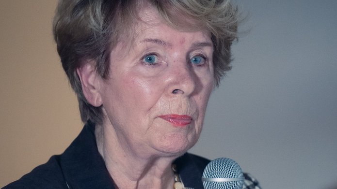 an elderly woman holding a microphone