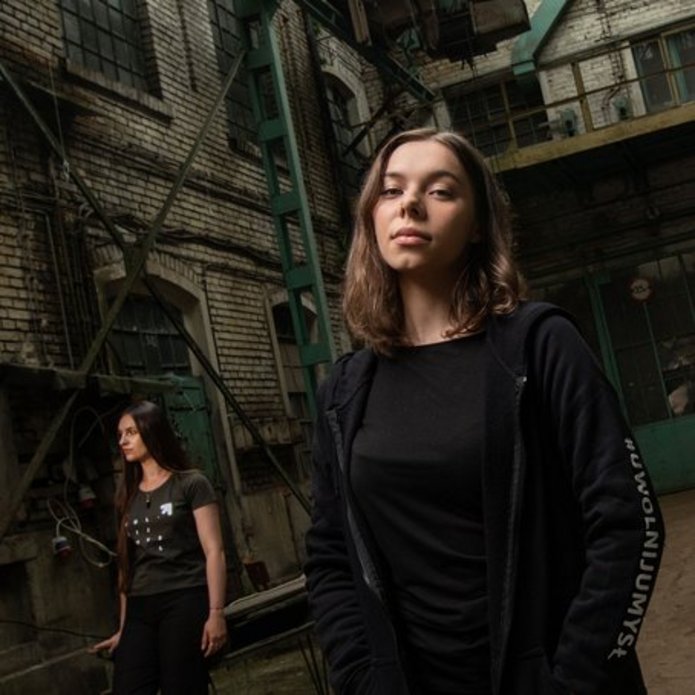 young women standing in a former factory space