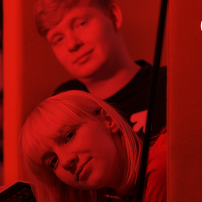 Dziewczyna i chłopak w bibliotece, na czerwonym tle 