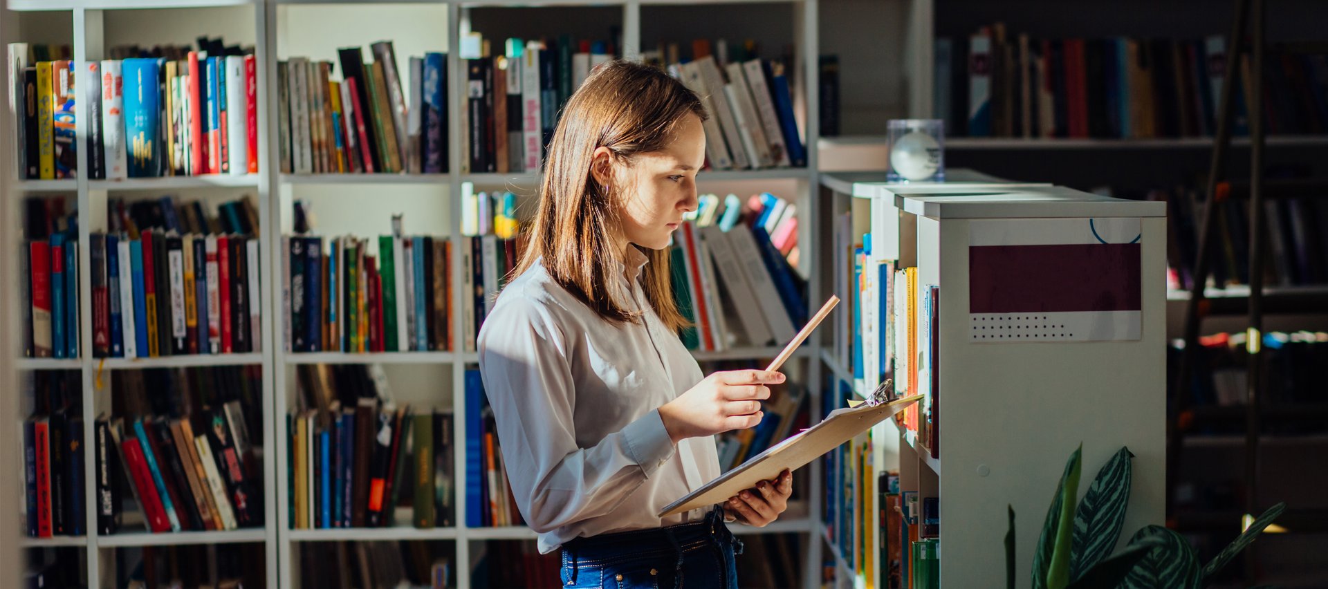 Dziewczyna szuka książek w bibliotece