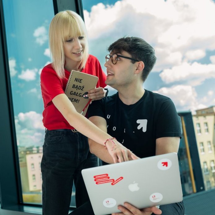 dziewczyna i chłopak siedzą przy laptopie