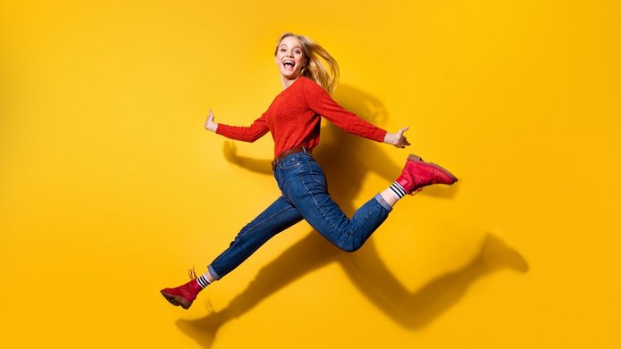 [Translate to English:] Uśmiechnięta studentka na żółtym tle