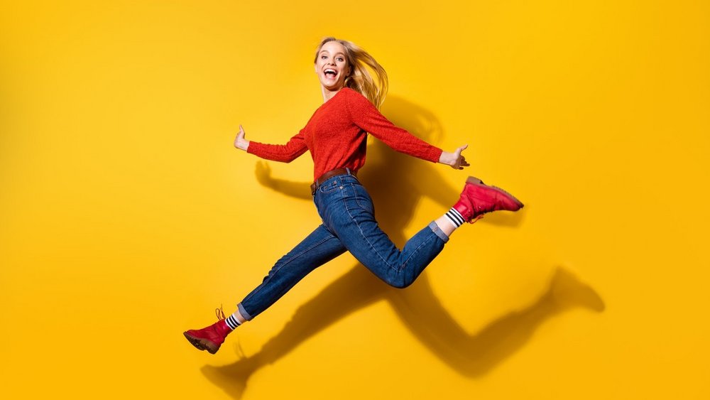 [Translate to English:] Uśmiechnięta studentka na żółtym tle