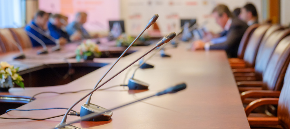 zdjęcie przedstawiające salę konferencyjną z mikrofonami