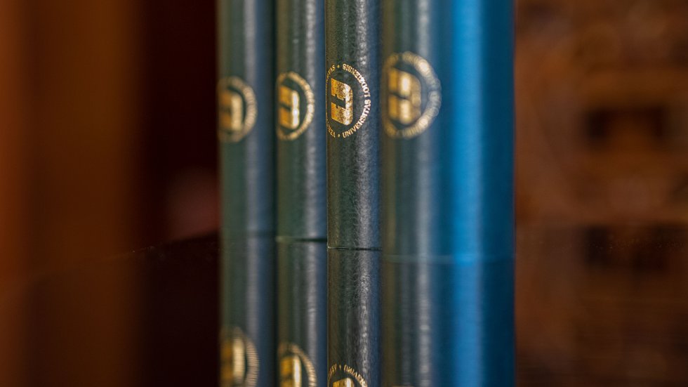 Zielone tuby ze złotym logotypem UŁ, w których znajdują się pamiątkowe dyplomy