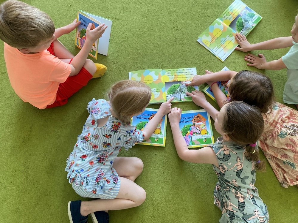 [Translate to English:] Dzieci przedszkolne czytające książeczkę