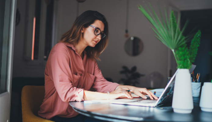 Kobieta siedząca przy biurku, pracująca na komputerze