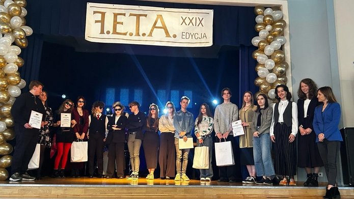 grupa ludzi stoi na scenie 