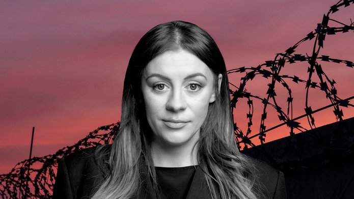Aleksandra Leszczyńska na tle linii drutu kolczastego przy zachodzie słońca
